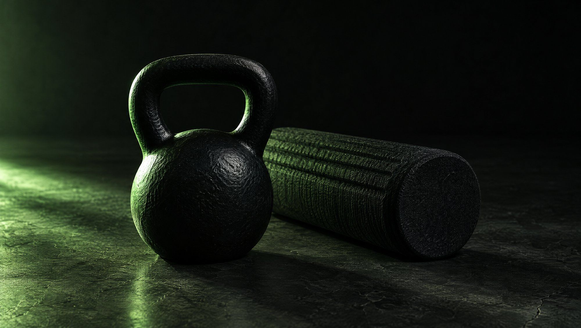 A black cast-iron kettlebell beside a dark foam roller on a concrete gym floor, edged in green light.